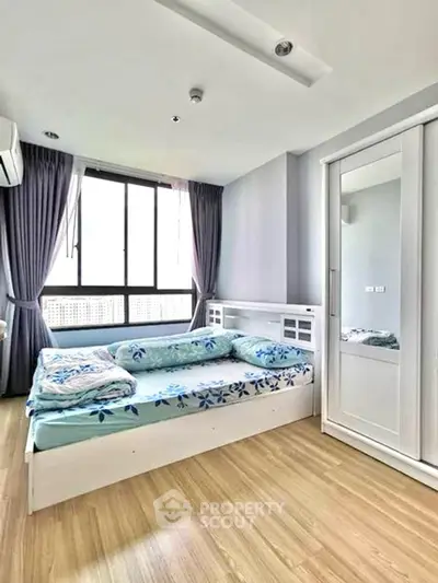 Bright and cozy bedroom with modern furnishings and large window view.