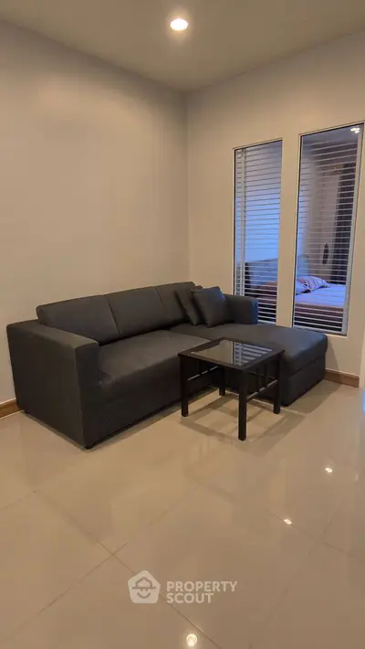 Modern living room with sleek gray sofa and glass coffee table