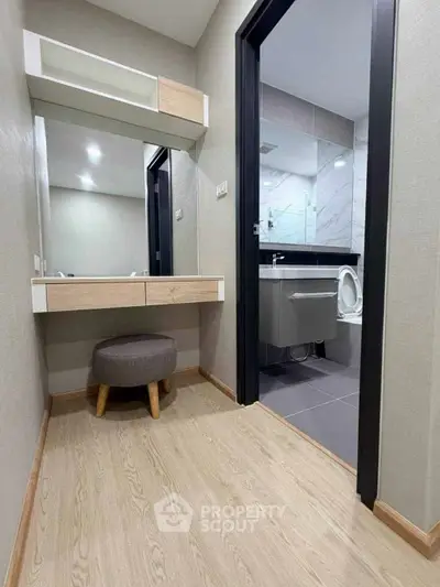 Modern bathroom with sleek design and wooden flooring, featuring a stylish vanity and contemporary fixtures.