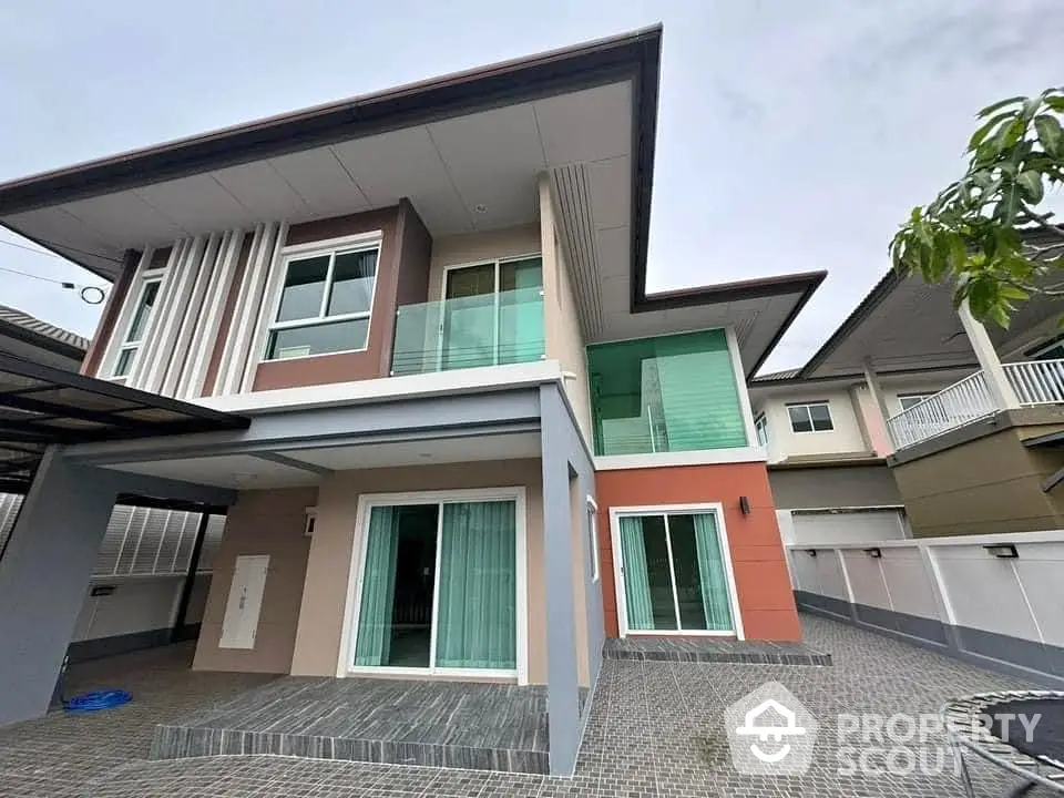 Modern two-story house with large windows and spacious driveway