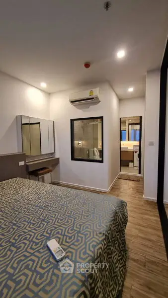 Modern bedroom with stylish decor and ensuite bathroom in a contemporary apartment.