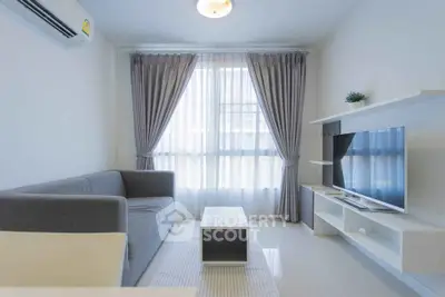 Modern living room with sleek furniture and large window for natural light.