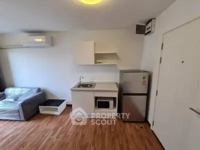 Modern studio apartment with compact kitchen and cozy living area, perfect for urban living.