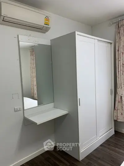 Cozy bedroom with built-in wardrobe and wall-mounted air conditioning unit.