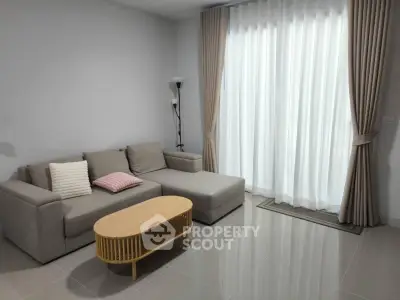 Modern living room with stylish sofa and elegant curtains in a bright, spacious apartment.