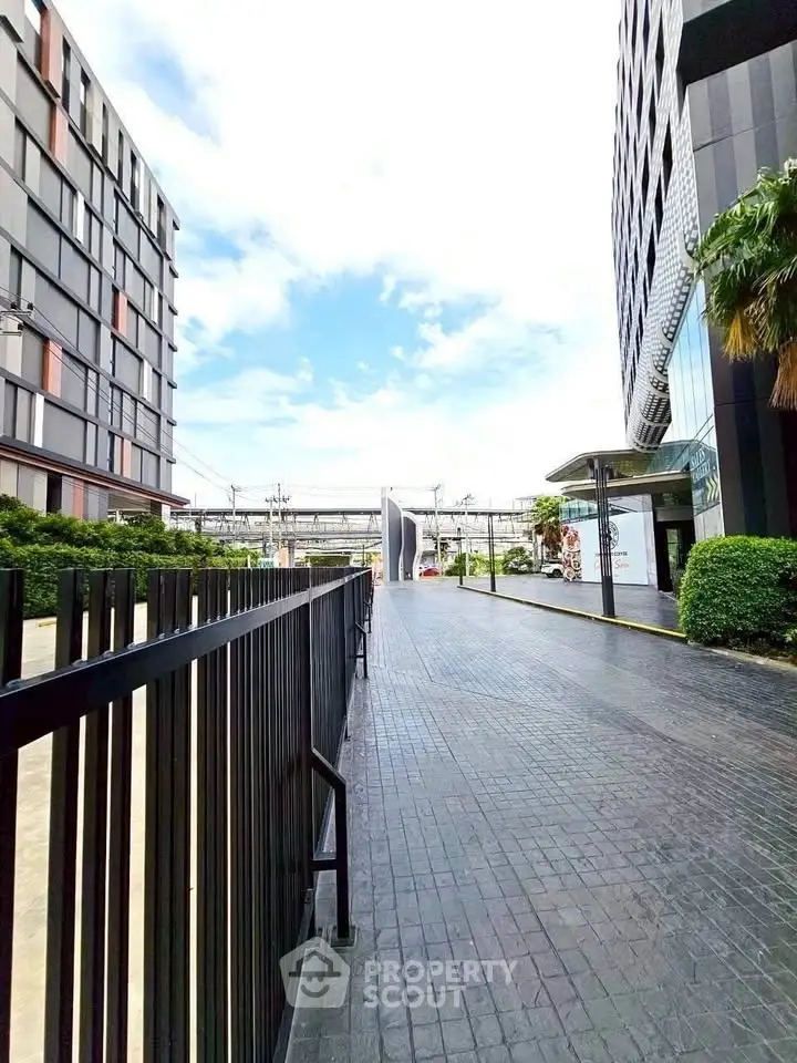 Modern building exterior with sleek design and lush greenery, showcasing urban architecture and inviting entrance.