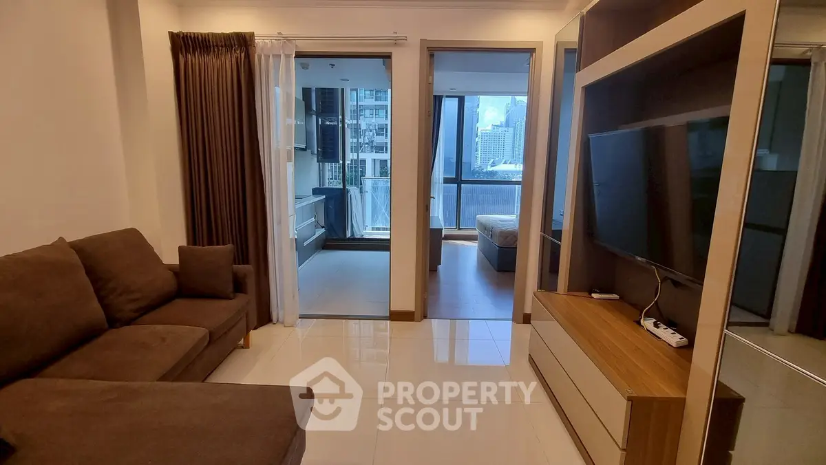 Modern living room with city view, sleek furniture, and natural light.