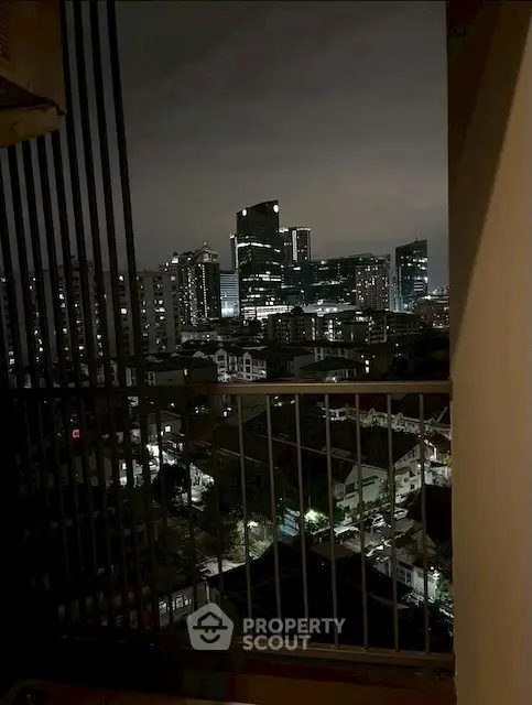 Stunning cityscape view from a high-rise balcony at night, showcasing urban skyline.