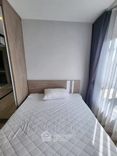 Cozy bedroom with natural light and modern wooden furnishings, perfect for relaxation.