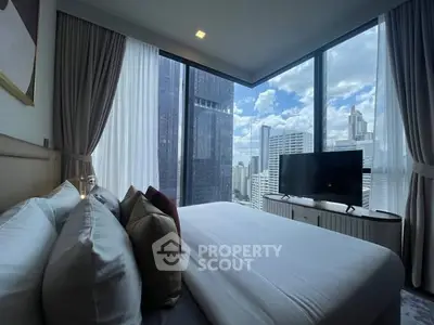 Luxurious bedroom with stunning city view and modern decor in high-rise apartment.