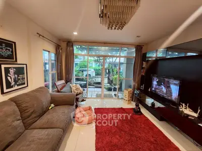 Spacious living room with modern decor, large windows, and garden view, perfect for relaxation and entertainment.