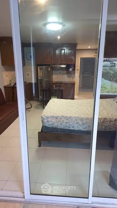 Cozy studio apartment with open kitchen and garden view, perfect for modern living.