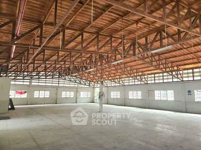 Spacious industrial warehouse with high wooden ceiling and ample natural light