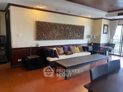 Spacious living room with elegant decor and large wall art, featuring a cozy seating area and natural light.