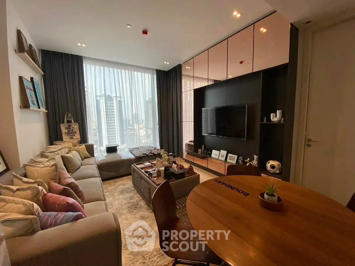 Modern living room with city view, stylish decor, and cozy seating area in a high-rise apartment.