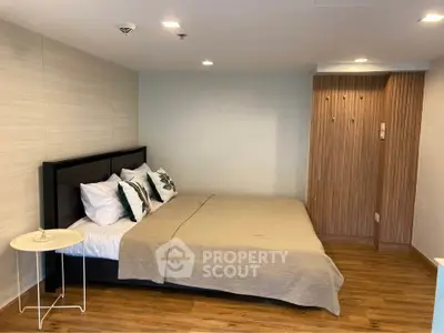 Spacious bedroom with modern decor and wooden flooring in a stylish apartment.