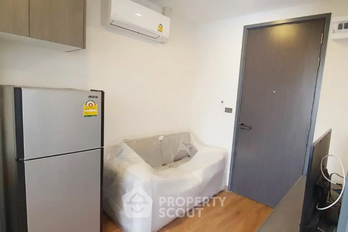 Modern apartment interior with compact living area and kitchen appliances