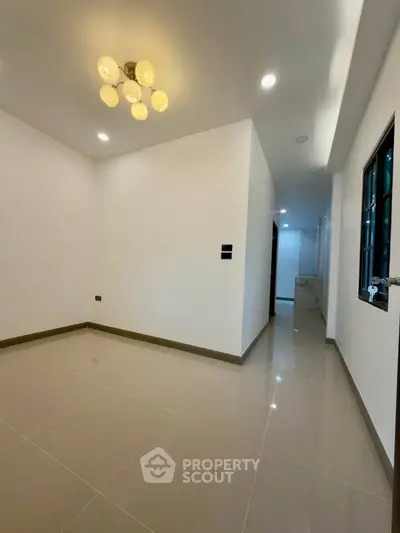 Spacious empty room with modern lighting and glossy tiled flooring, ideal for customization.