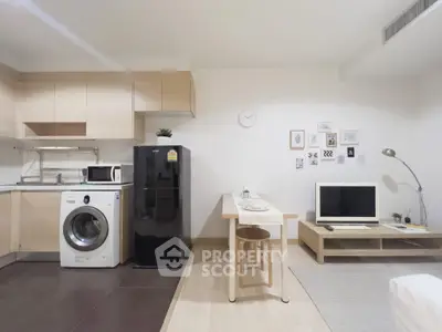 Modern studio apartment with open kitchen, washing machine, and cozy living area.