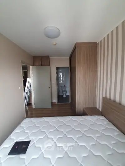 Cozy bedroom with wooden accents and ensuite bathroom in modern apartment