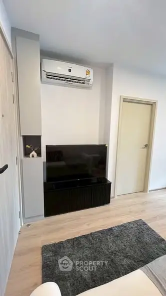 Modern living room with sleek TV setup and air conditioning unit