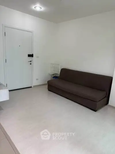 Minimalist living room with brown sofa and white walls, perfect for cozy living.