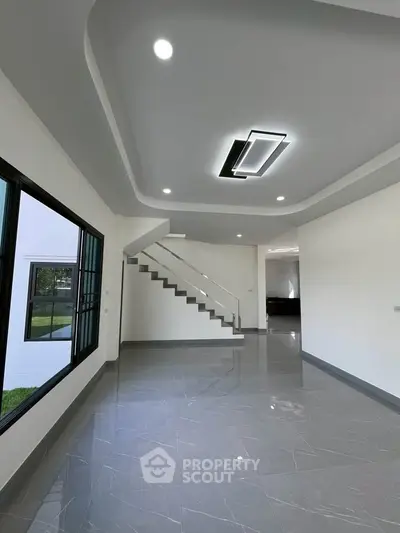 Modern interior with sleek staircase and glossy tile flooring in a spacious living area.