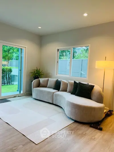 Stylish living room with modern sofa and garden view, perfect for relaxation.