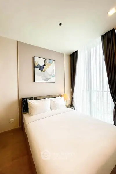 Modern bedroom with large window and stylish decor in a high-rise apartment.