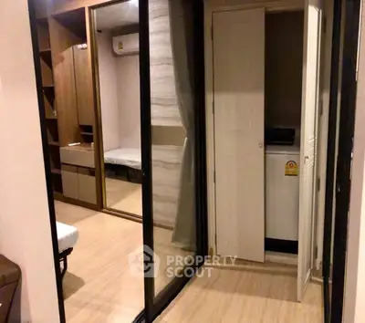 Modern apartment interior with mirrored closet and washing machine area