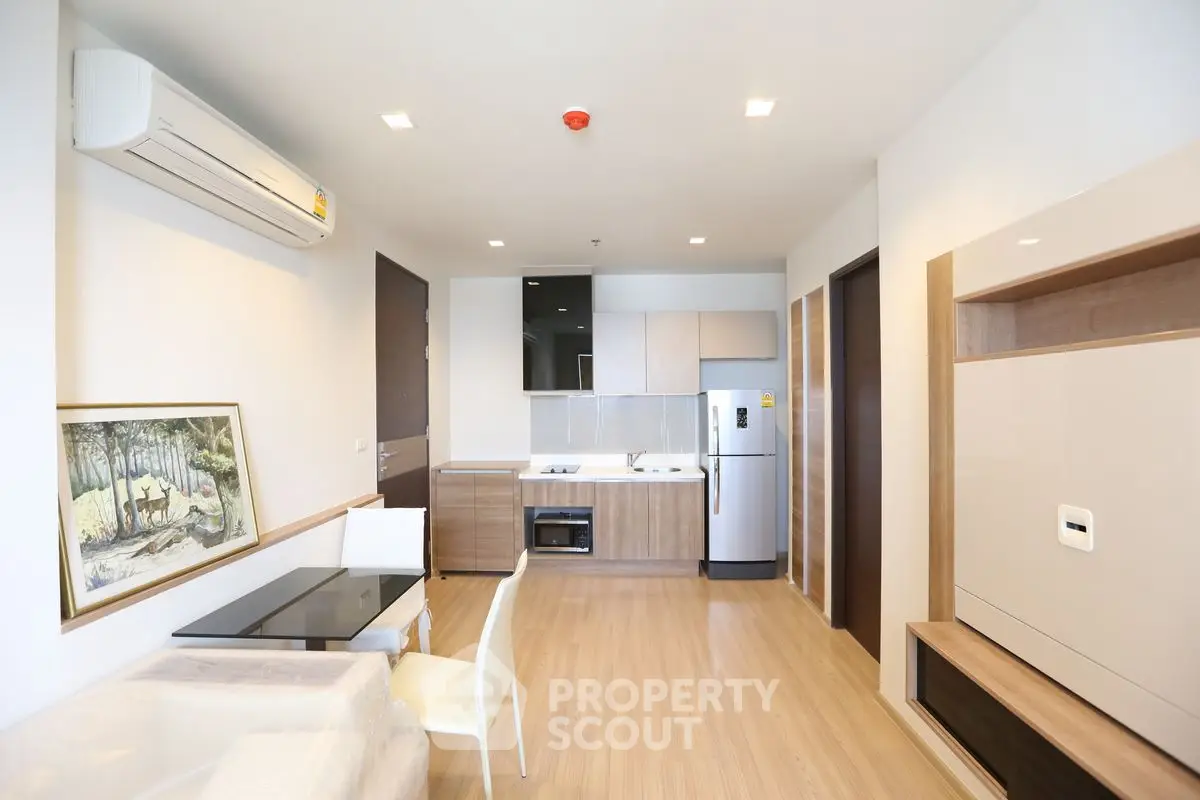 Modern open-layout living room with kitchen, featuring sleek furniture and contemporary design.