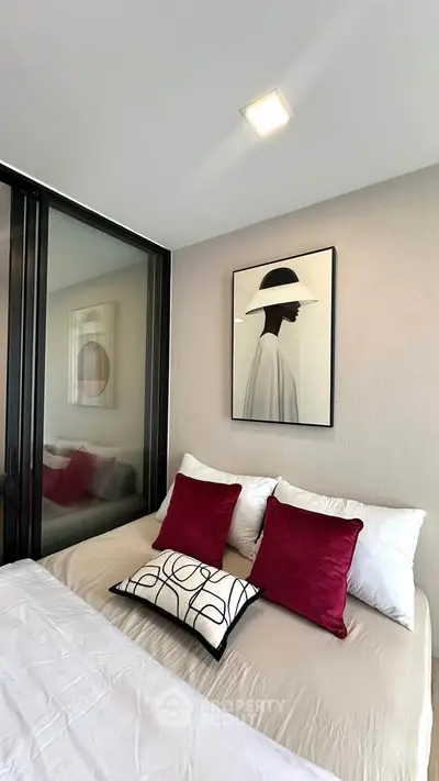 Modern bedroom with stylish decor and elegant artwork, featuring plush pillows and a cozy ambiance.