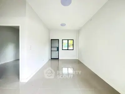 Spacious empty room with glossy tiled floor and large window, perfect for customization.