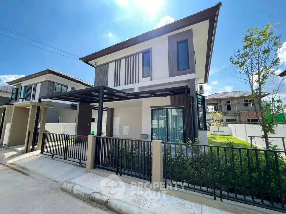 Modern two-story house with sleek design and spacious yard in a sunny neighborhood.