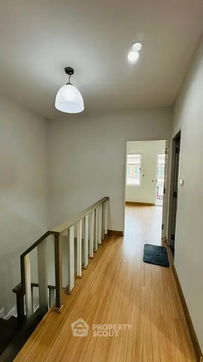 Modern hallway with wooden flooring and stylish lighting in a contemporary home.