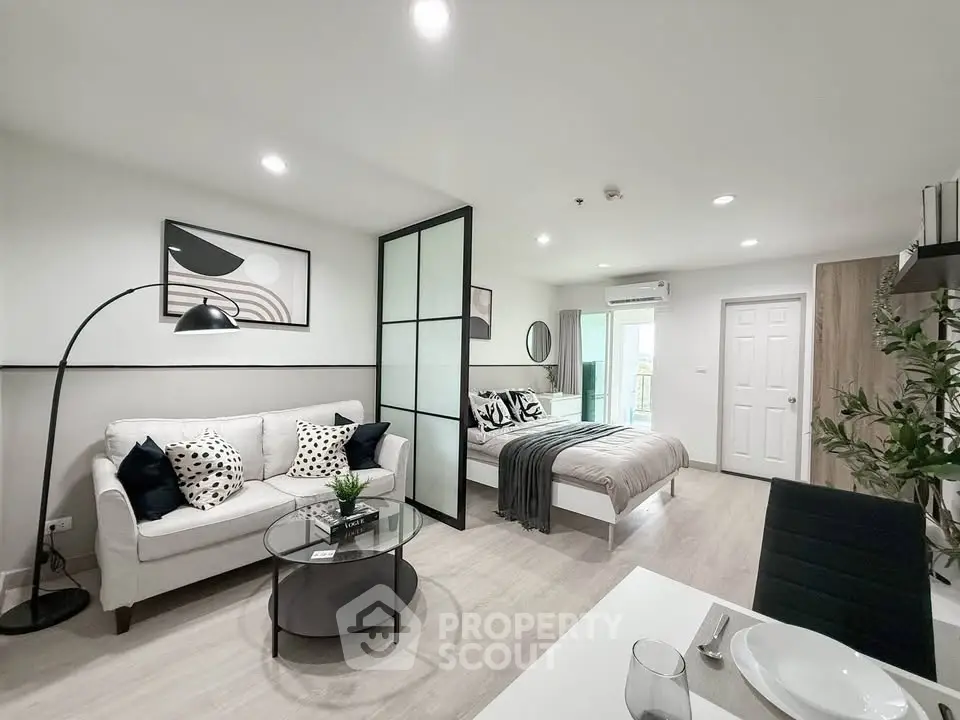 Modern open-plan living room and bedroom with stylish decor and natural light