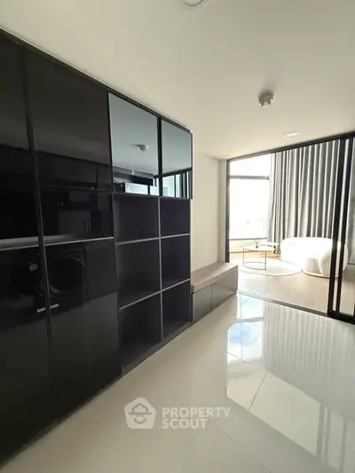 Modern apartment interior with sleek black cabinetry and bright natural light.