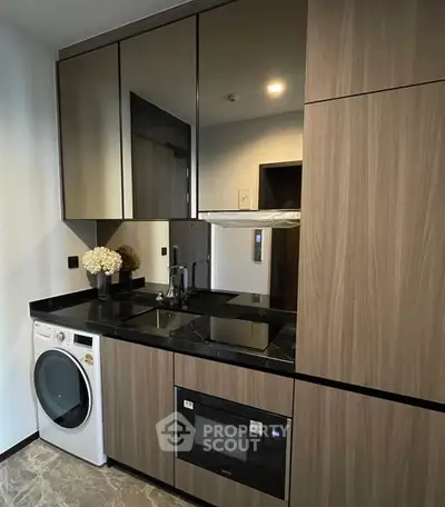 Modern kitchen with sleek cabinetry, built-in appliances, and elegant black countertops.