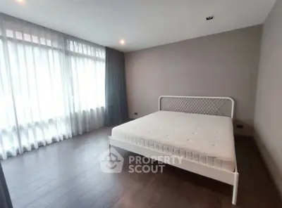 Spacious bedroom with large windows and modern minimalist design