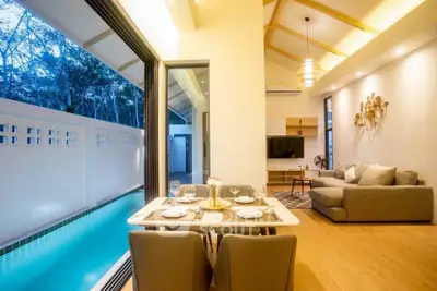 Luxurious open-plan living room with pool view, modern decor, and elegant dining area.