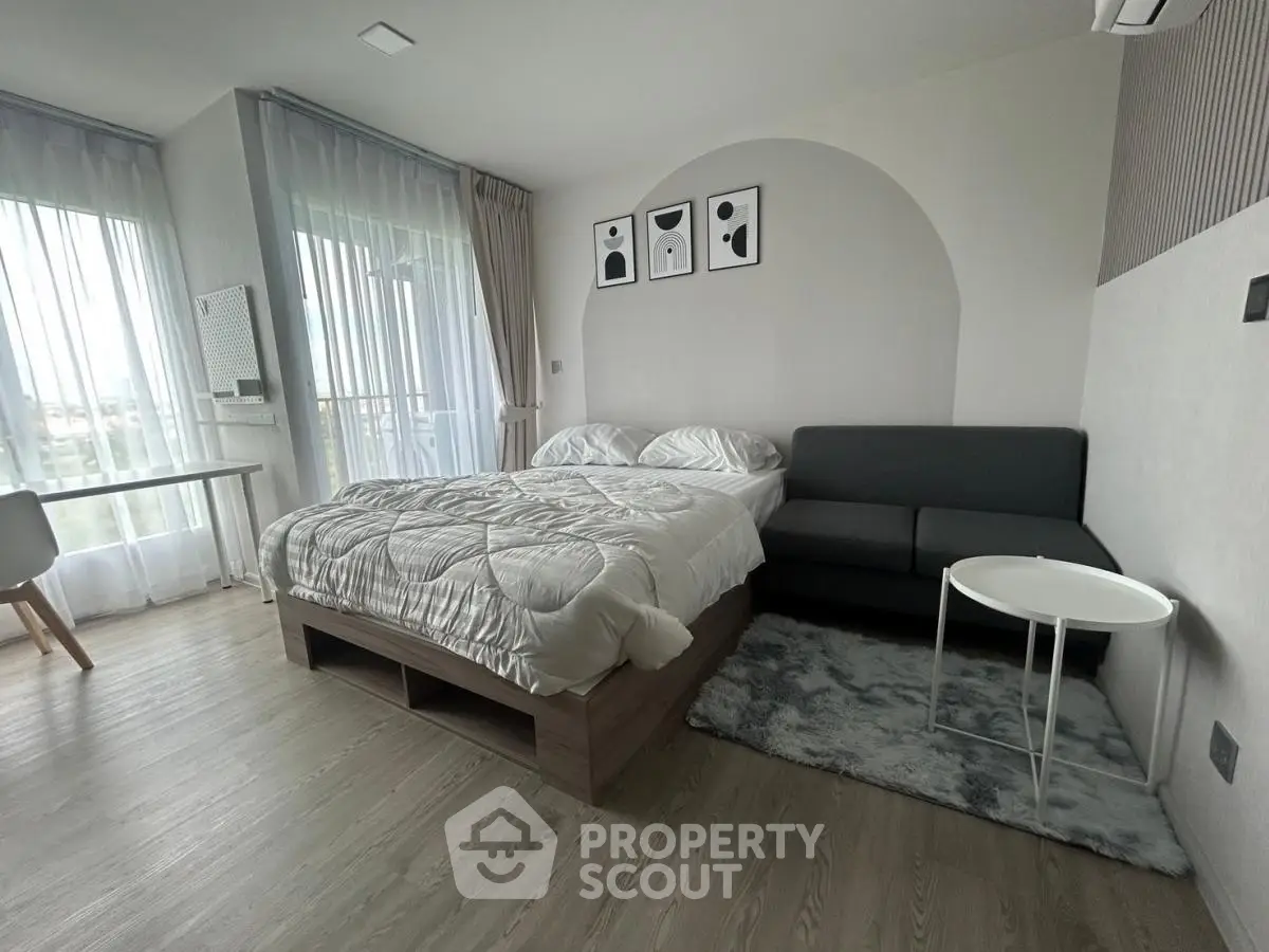 Modern bedroom with stylish decor and natural light, featuring a cozy bed and elegant furnishings.