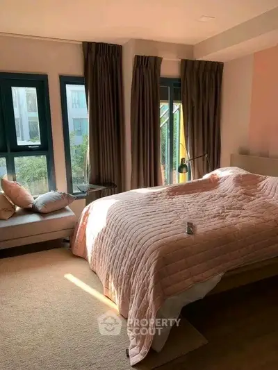 Cozy bedroom with large windows and elegant decor in a modern apartment.