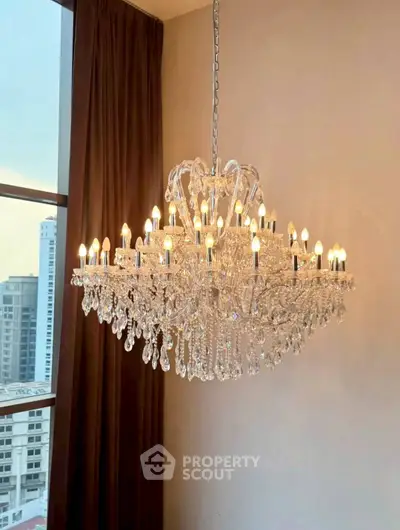 Luxurious crystal chandelier in elegant living room with city view