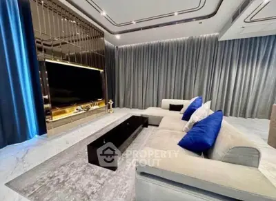 Luxurious modern living room with plush sofa and large TV, perfect for relaxation and entertainment.
