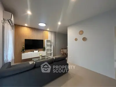 Modern living room with sleek design and wall-mounted TV, perfect for relaxation and entertainment.