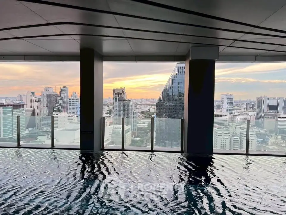 Stunning rooftop pool with panoramic city skyline views at sunset.