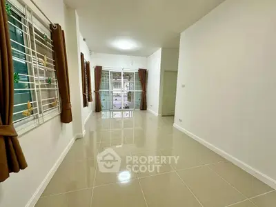 Spacious empty living room with tiled flooring and large windows