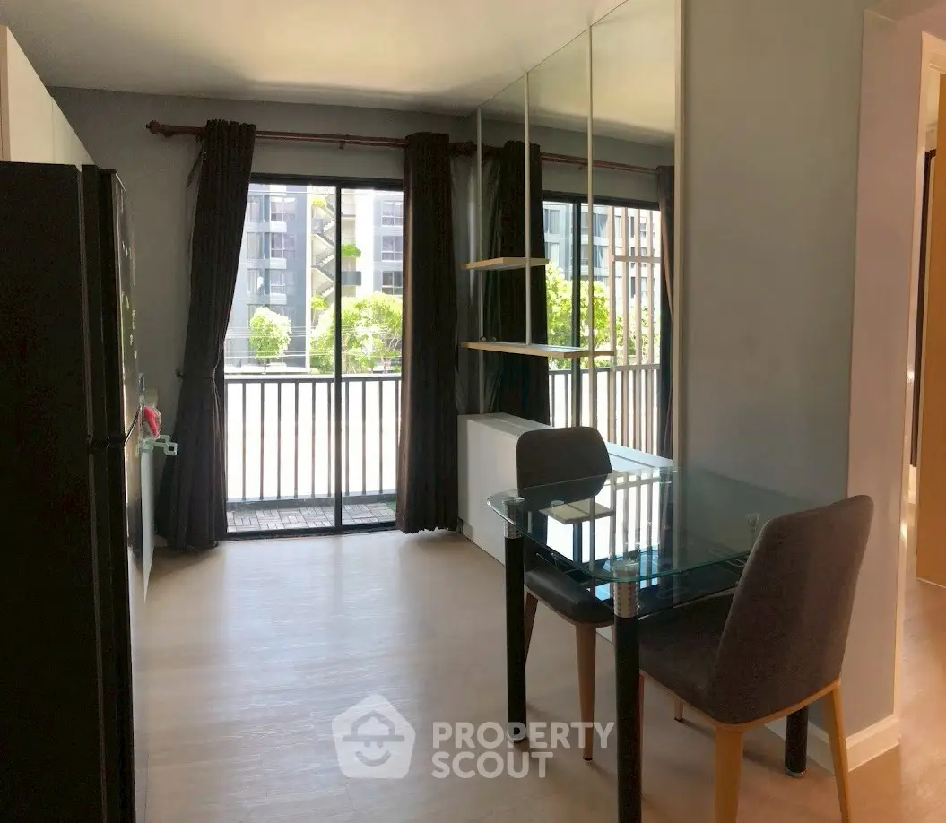 Modern apartment dining area with glass table and balcony view