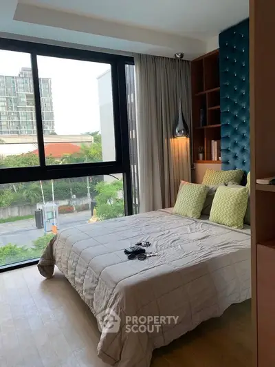 Modern bedroom with large window and stylish decor in urban apartment