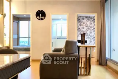 Modern living room with elegant decor and large windows offering natural light.